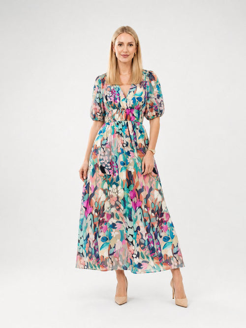 Woman wearing a colorful floral dress on a white background front view
