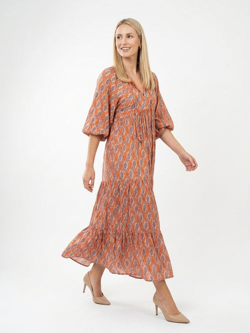 Woman wearing a patterned dress on a white background